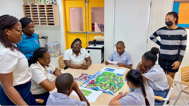 Students, teachers, and administrators at the Asha Stevens Christian Hillside School in Sint Maarten play a board game