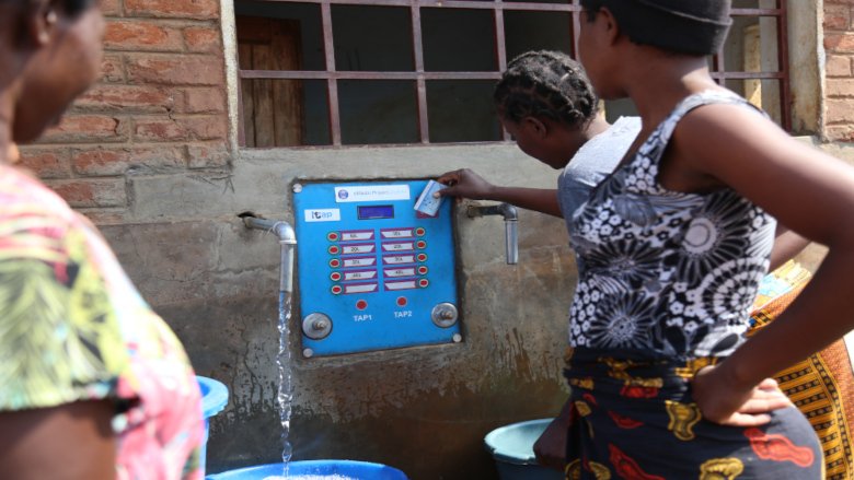 A woman swiping her card to draw water at the e-madzi kiosk in Lilongwe. Credit: Henry Chimbali/World Bank 