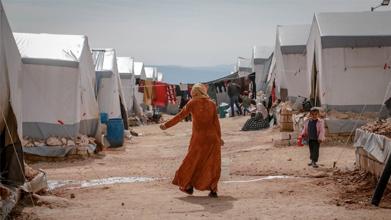 Anonymous woman walking in refugee camp. Photo credit: Ahmed Akacha
