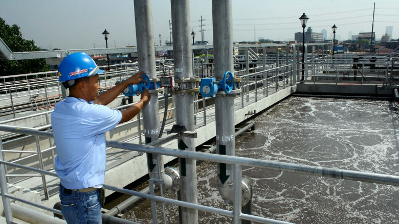 A worker at a  wastewater treatment facility in Southeast Asia