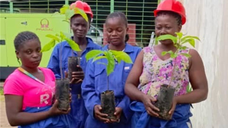 Local women planting avocado tree saplings at the Kimwenza site.