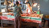 A woman buys meat at a fresh market in Vientiane, Laos. 