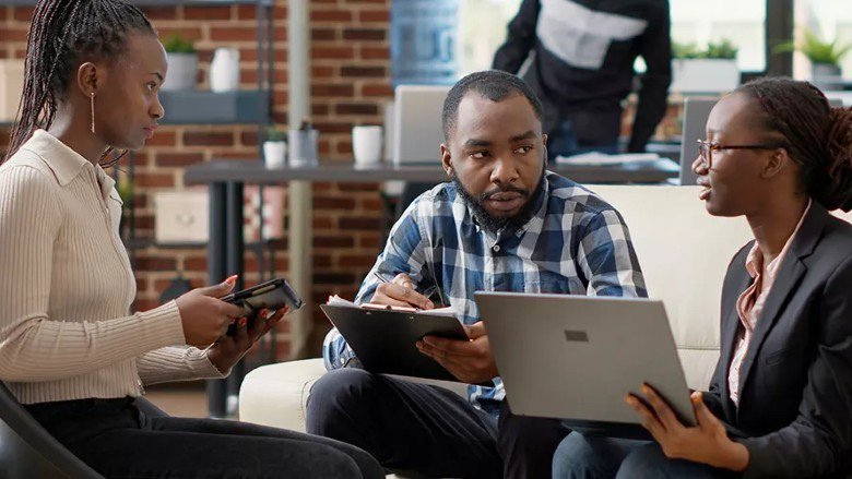 Young African professionals holding laptops and a tablet discuss what it takes to create a single digital market in Africa