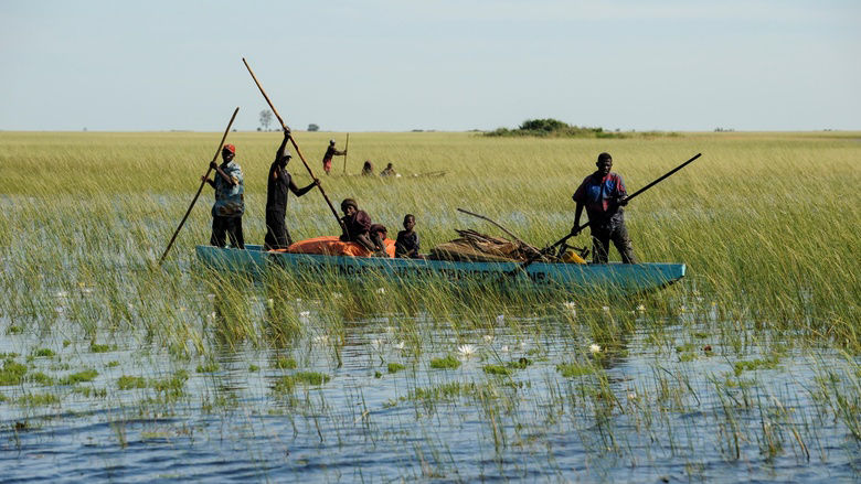 People travel by boat on the Zambezi river along the Barotse plain, Zambia. Credit: Joerg Boethling/Alamy