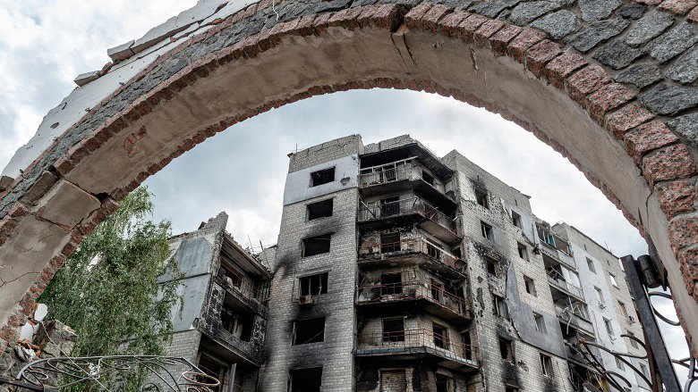 An archway in front of a damaged building in Ukraine