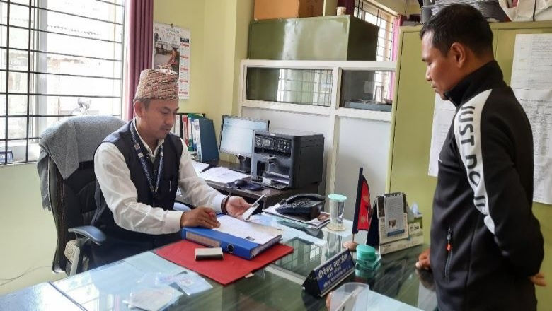 Birendra Maharjan, Secretary of Lalitpur Metropolitan City, Ward 4, interacts with a service seeker in his office