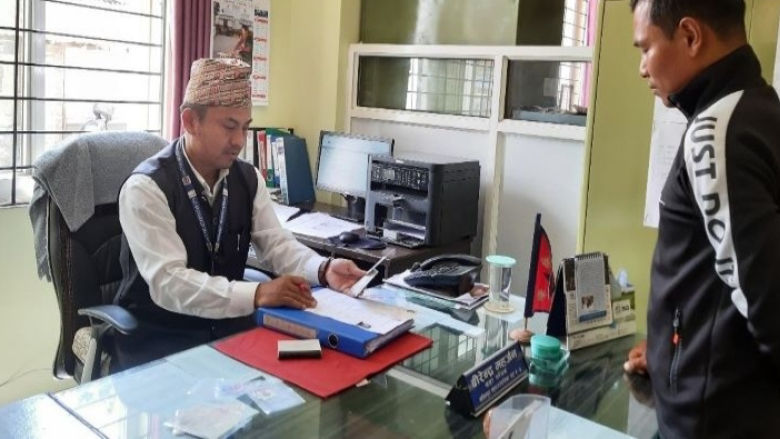 Birendra Maharjan, Secretary of Lalitpur Metropolitan City, Ward 4, interacts with a service seeker in his office