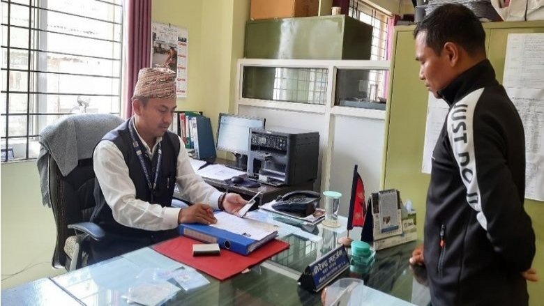 Birendra Maharjan, Secretary of Lalitpur Metropolitan City, Ward 4, interacts with a service seeker in his office