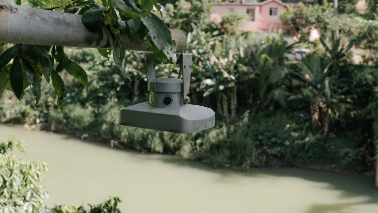 A camera looking device used to monitor water levels hangs over a river in central Jamaica.