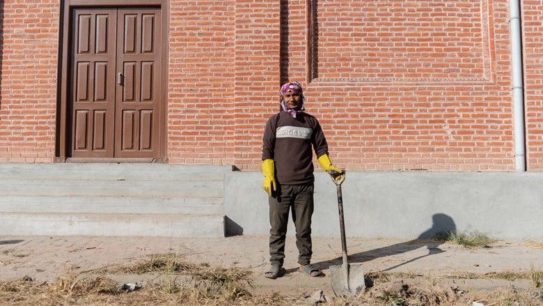 A man stands with a shovel in his hand