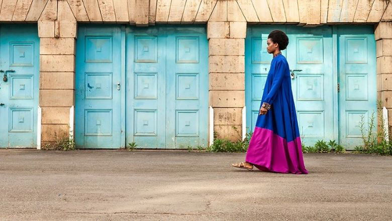 woman walking turqoise doors
