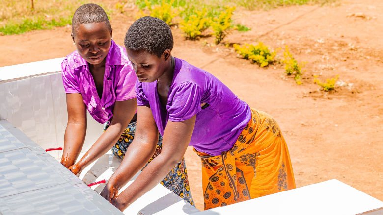 Alpina Mwampumba and Anna Mwalengo washing their hands at the Itepuladispensary handwashing station