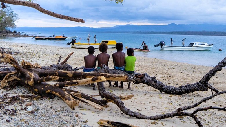 Children sitting on beach in Tongoa Island, Vanuatu after Tropical Cyclone Harold hit in April 2020 
