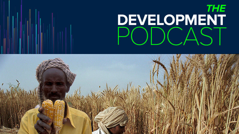 Farmer holding maize in a field with a backdrop saying 