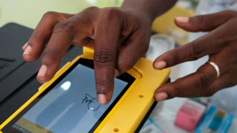 Person uses a tablet device to provide an electronic signature during digital identity verification on a mobile platform.