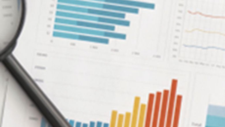 Graphic of data on paper with a magnifying glass
