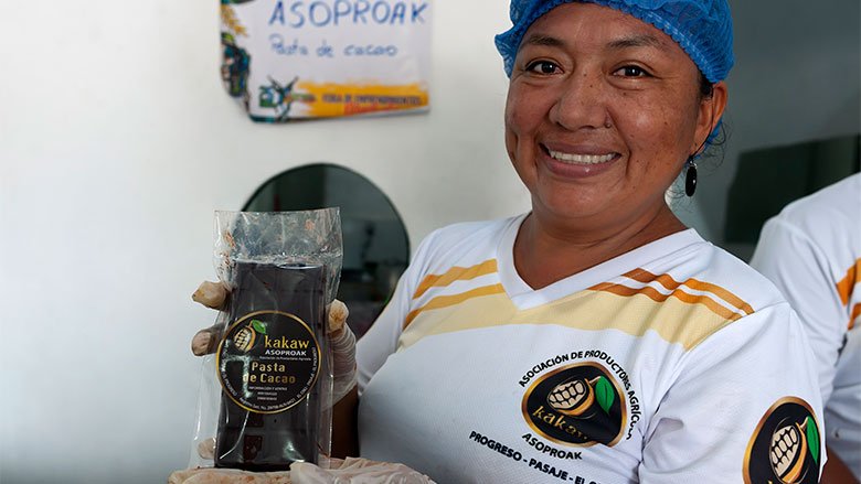 Trabajadora de la Asociación de Productores Agrícolas Kakaw mostrando orgullosa el chocolate. producido y listo para venta.