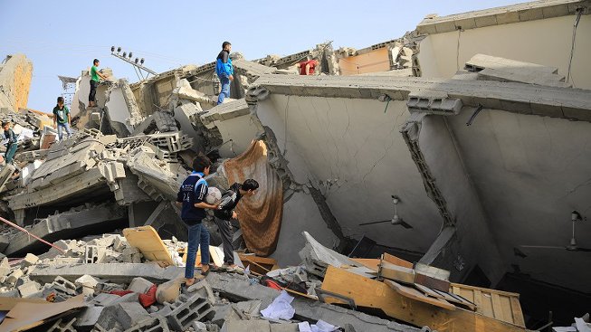 People looking through debris after an earthquake in Hatay, Türkiye 