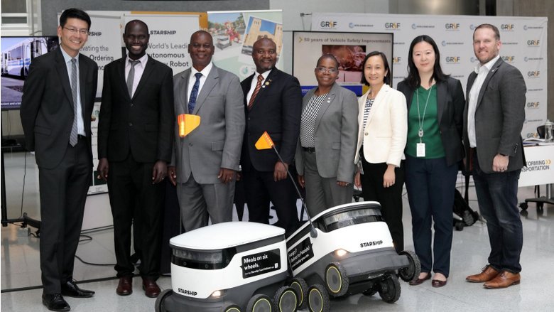 A photo of delegates standing in front of robots.