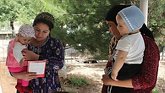 Two women holding their babies in Central Asia