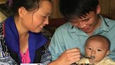 parents feeding their infant 