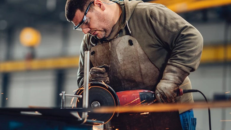 Factory worker grinding metal