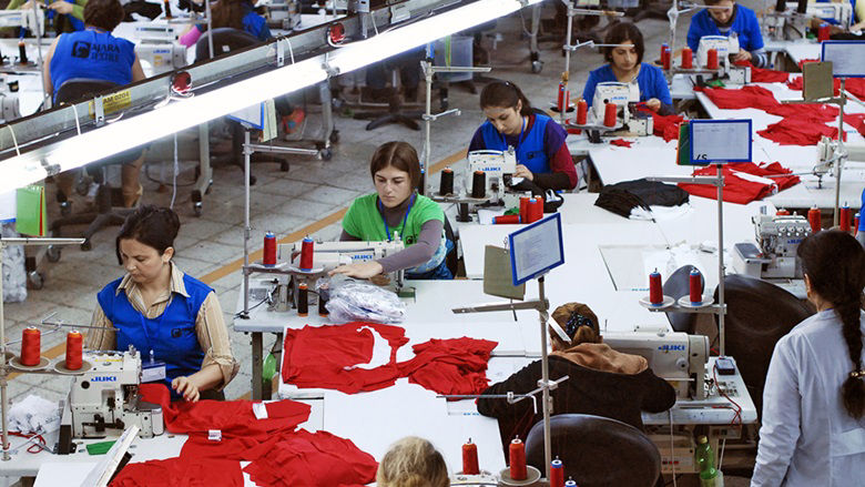 women working on sewing machines in textile manufacturing company 