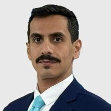 Man with dark blue suit and light blue tie