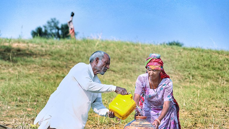 A photo of a woman and man fetching water