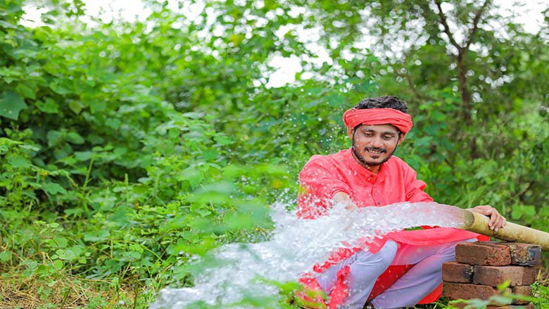 An image of a man holding a water hose