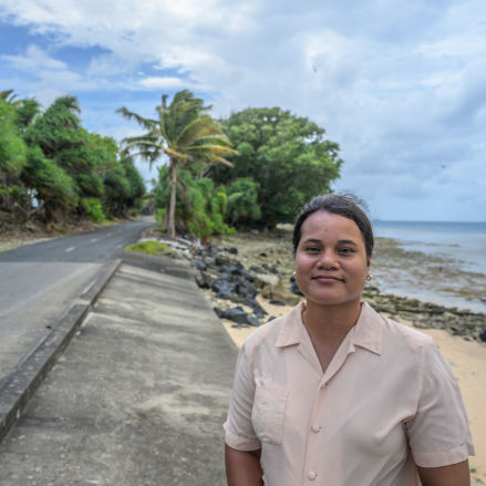 Portrait of Youth Climate Activist Grace Malie facing the camera with the Tuvalu shore in the background.