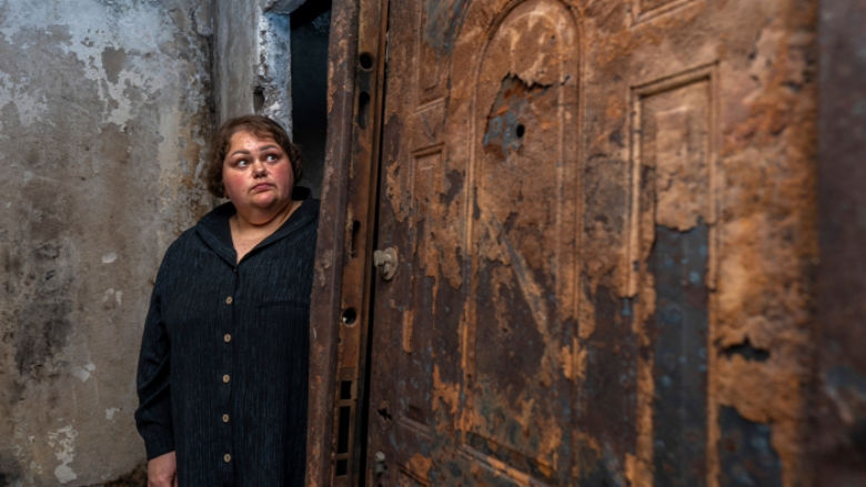 Woman looking at destroyed apartment in Ukraine.