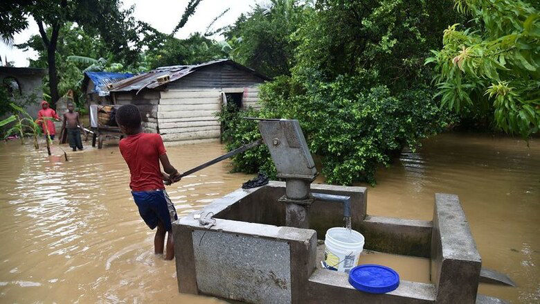 Niños en calle inundada en Haití después del Huracán Matthew
