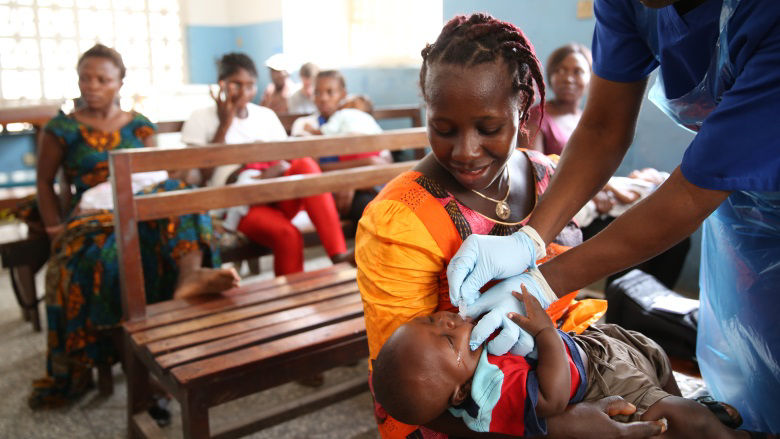 Woman vaccinates her 5-week-old son in Sierra Leone