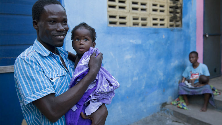 Gideon Abossey holds his daughter Emmanuel after giving her bath in Mamobi neighborhood in Accra, Ghana on October 15, 2015. 