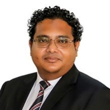 Male wearing black suit and white blouse