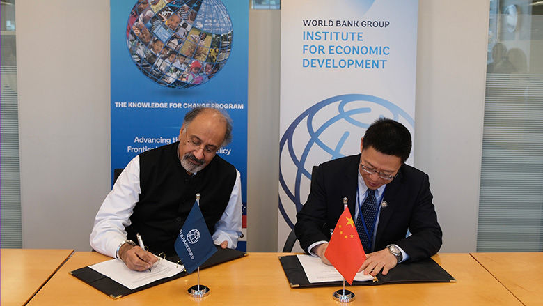 Indermit Gill, World Bank and Liao Min, Ministry of Finance, China signing agreement documents