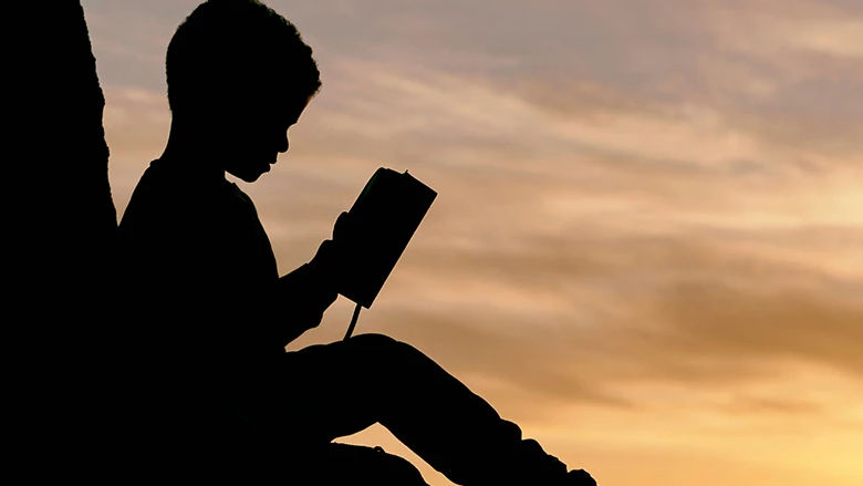 dark figure of a kid reading