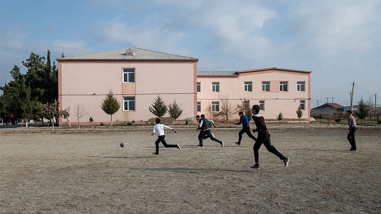 School children running outside, in Qardili village.