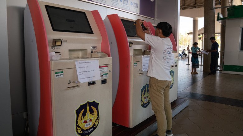 A man uses an automatic payment machine to pay customs duty on imported goods at the  Laos-Thailand border near Vientiane