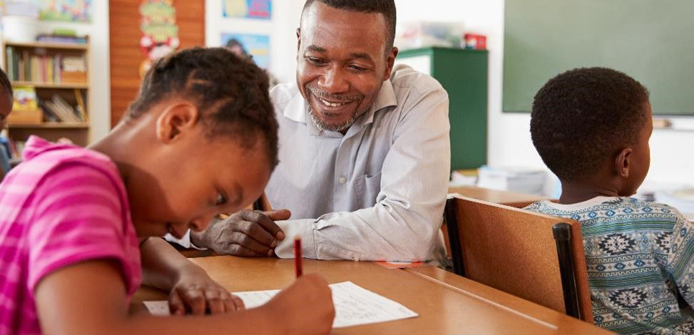 Teacher assists student with her work