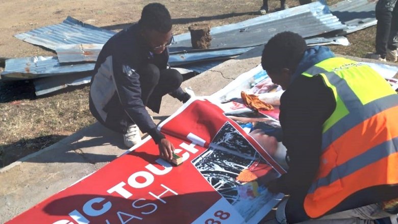 Workers putting up a sign in Lesotho