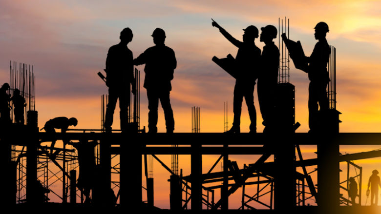 Construction workers standing on beams