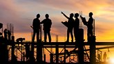 Construction workers standing on beams