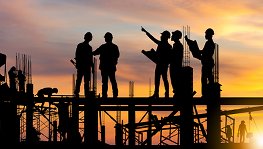 Construction workers standing on beams