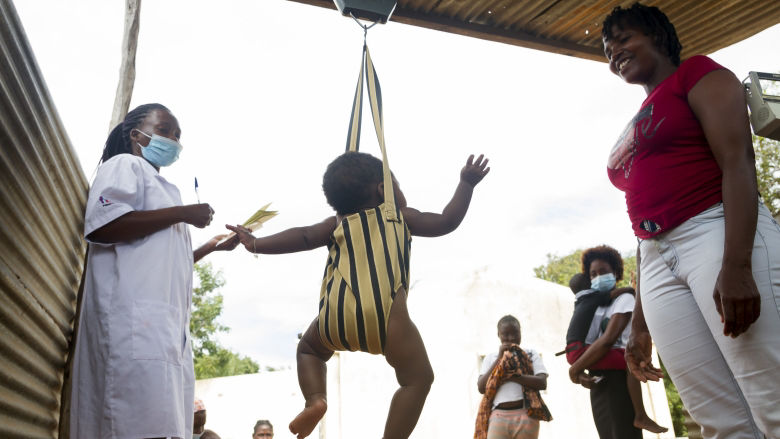 Health workers monitor child growth during a routine check‑up at a community health facility in Mozambique. 