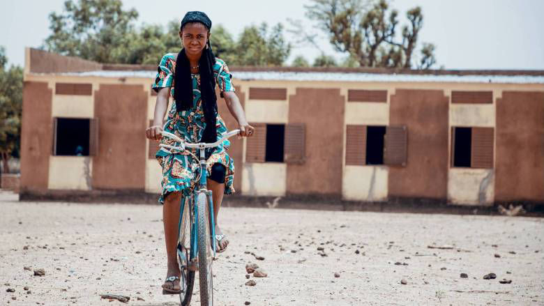 A girl rides her bicycle to school in Mali.