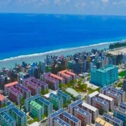 Modern buildings with rooftop solar panel along the Maldives coastline. 