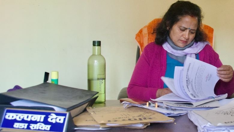 Kalpana Deo signs paper in her office