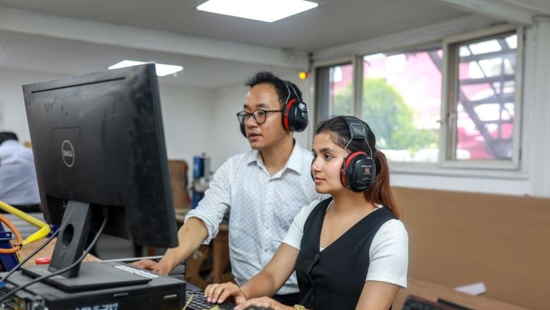 employees at Impact Hub look at a computer screen